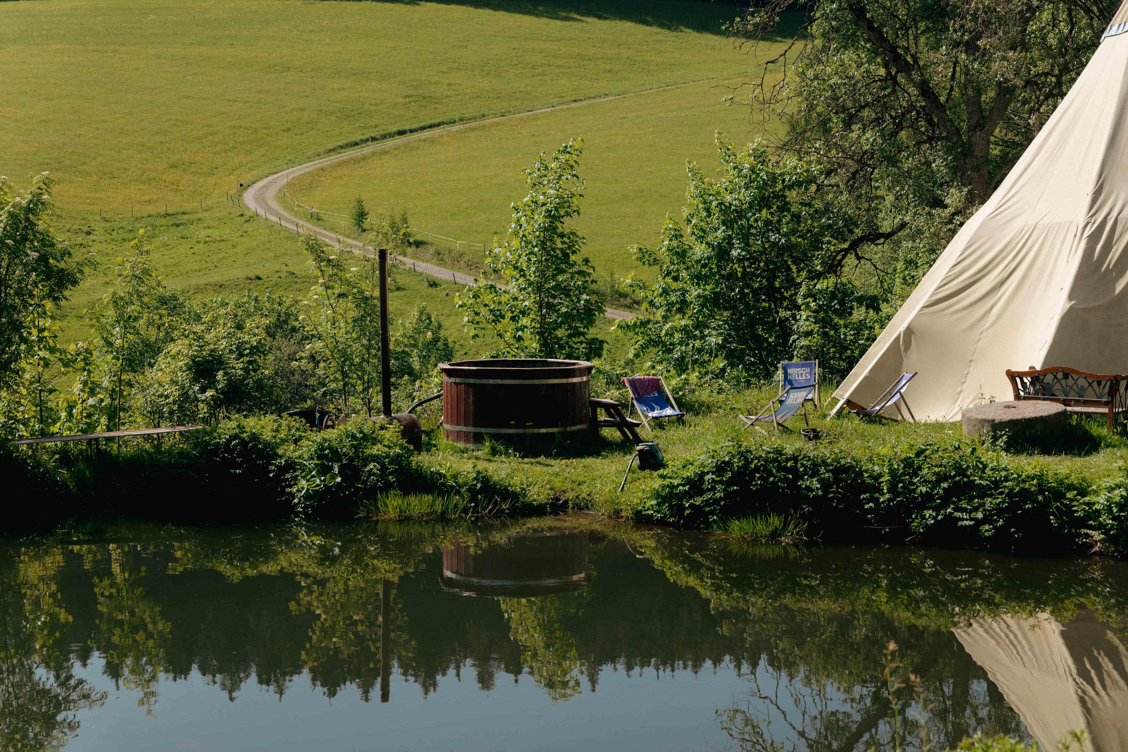 Holzbadefass und Tipi-Zelt auf der grünen Wiese des Campingplatzes Zum Wilden Michel im Schwarzwald